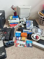Overall lot showing power strips, office supplies, binoculars, paper shredder, printer