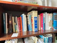 Books on upper shelf showing dictionaries, reference and literature titles