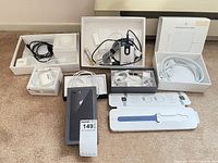 Overview of all items laid out including boxes, power adapters, cables, Sandisk reader, iPhone box, watch band