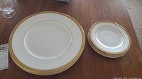 Dinner plate and stacked side plates showing pattern and gold rim