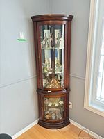 Full view of corner curio display cabinet showing overall design and finish