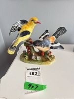 Front view of two-bird bone china figurine with measurement card