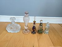 Group shot of five decorative glass perfume bottles lined up
