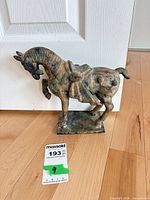 Left side view of Toyo cast metal horse figurine on wood floor