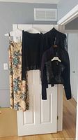 All four garments hanging: floral dress and three black jackets