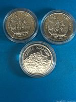 Group view showing all three encapsulated commemorative coins