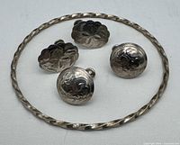 Full view of twisted bangle and four screw-back earrings