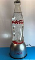 Full front view of Coca-Cola bubble lamp showing bottle shape, logo, and base