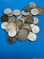 Pile of assorted Belize coins on blue surface