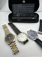 All three wristwatches, storage case, extra straps in view