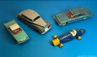 All four Dinky Toys cars arranged on blue background