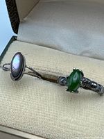 Two sterling silver rings in jewelry box showing stone settings and metal condition