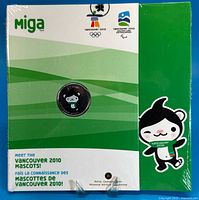 Front of sealed display card with coin and Miga mascot artwork
