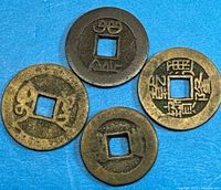 Front view of all four coins showing inscriptions and square holes