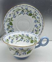Front view of teacup and saucer showing Harebell pattern and gold trim