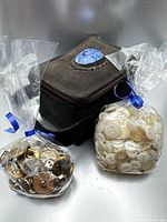 Overall lot showing suede-like box and two bags of buttons