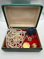 Open green presentation box with all jewelry pieces