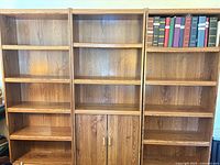 Front view of three matching oak bookshelves
