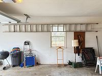 Full view of aluminum extension ladder mounted on garage wall