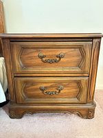 Front view of one nightstand showing two drawers, hardware, finish and base design