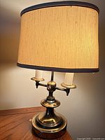 Full view of brass-plated table lamp with shade