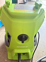 Front view of Earthwise pressure washer showing lime green casing and power dial, attached power cord visible