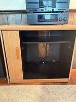 Front view of cabinet with door open showing shelf and equipment on top