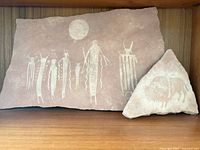 Rectangular and triangular etched sandstone slabs on shelf