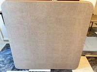Square textured beige laminate table top with rounded corners