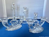 Five pressed glass candlesticks displayed together