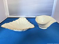 Triangular dish and gravy boat side by side, showing gold rims and white porcelain