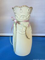 Front view of cream Lenox porcelain vase with ribbon and tag