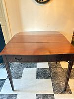 Full view of mahogany dining table with drop leaves folded down