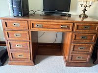 Front view of oak kneehole desk showing drawer configuration