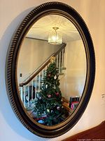 Front view of oval wall mirror showing full frame and reflection