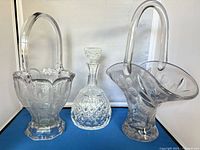 Group shot of two pressed-glass baskets and one decanter