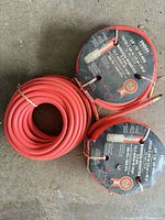 Three red RCR air hoses on reels showing labels and brass fittings
