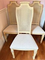 Three side chairs showing tall cane backs and upholstered seats