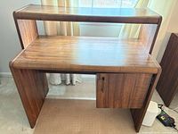 Front angled view of two-tier desk showing upper shelf, main surface, side cabinet