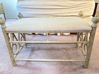 Front view of metal vanity bench showing upholstered seat and scrollwork frame
