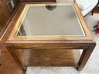 Full view of square wood end table with glass top and shelf