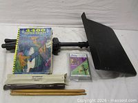 Group shot of stand desk, book, cassette, recorder case and drumsticks