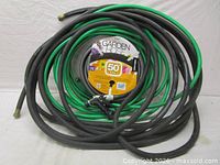 All three coiled hoses showing green and black colors with couplings and spray nozzle