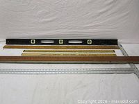 Black level, two wooden yardsticks, aluminum T-square displayed together