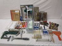 Group shot of entire lot showing caulk guns, sealant tubes, wire brushes, putty knives, trowels, brushes, rollers, sanding sheets