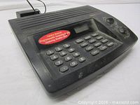 Front angled view of scanner radio showing keypad, display, knobs, and dust