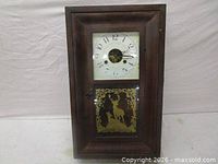 Front view showing entire wooden wall clock, glass door, stencil deer panel