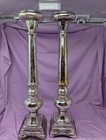Full view of both tall mercury glass style candle holders