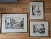 Overall view of the three framed Paris illustrations laid on floor