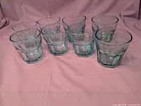 Set of eight light blue faceted juice glasses upright